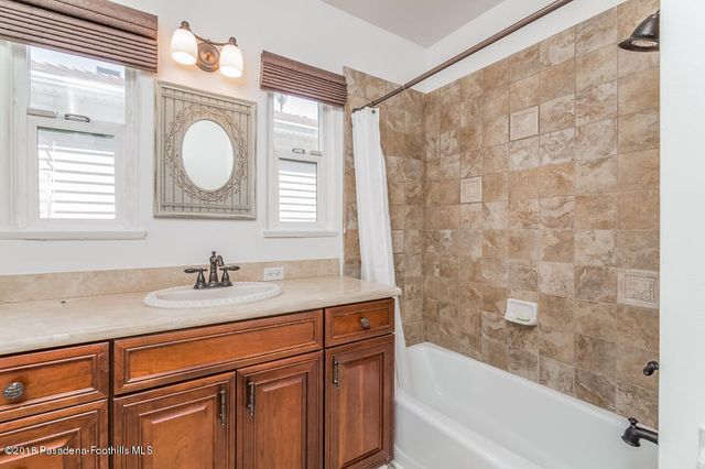 a bathroom with a granite countertop sink a mirror and a bathtub