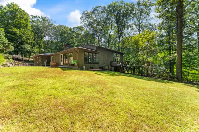 a view of a swimming pool with some plants and large trees