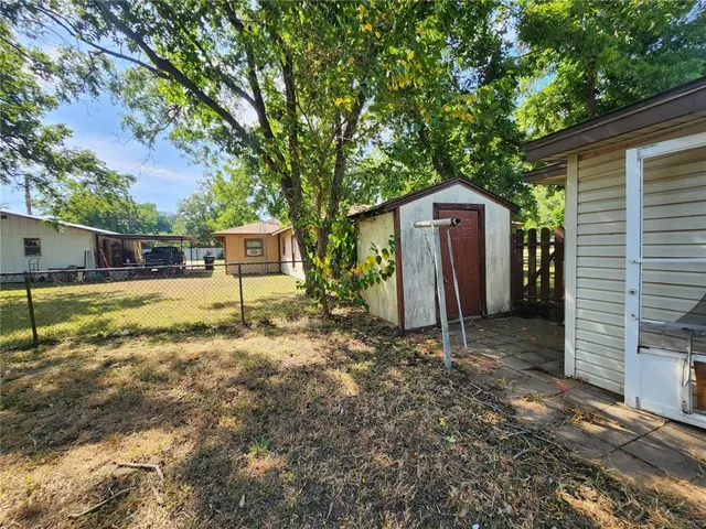 a view of a yard with tree and wooden fence
