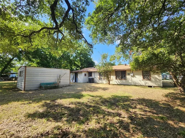 a front view of a house with yard and trees