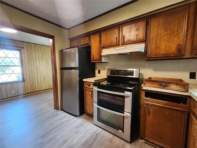 a kitchen with stainless steel appliances granite countertop a stove a refrigerator and a microwave