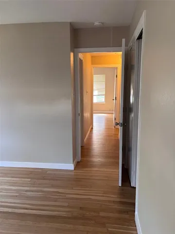 a view of an empty room with a window and cabinet