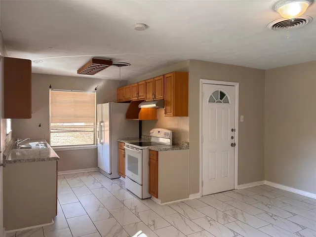 a kitchen with wooden cabinets and a stove top oven