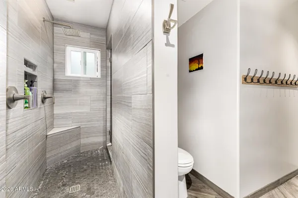 a bathroom with a granite countertop sink a toilet and shower