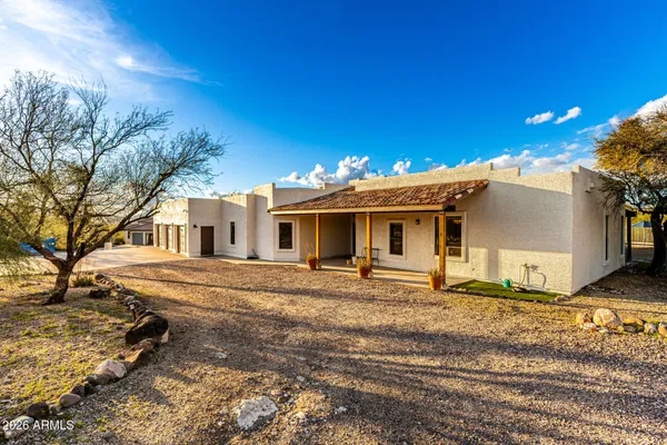 a view of a house with a patio and a yard