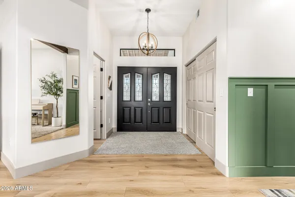 a view of a hallway with wooden floor and a chandelier