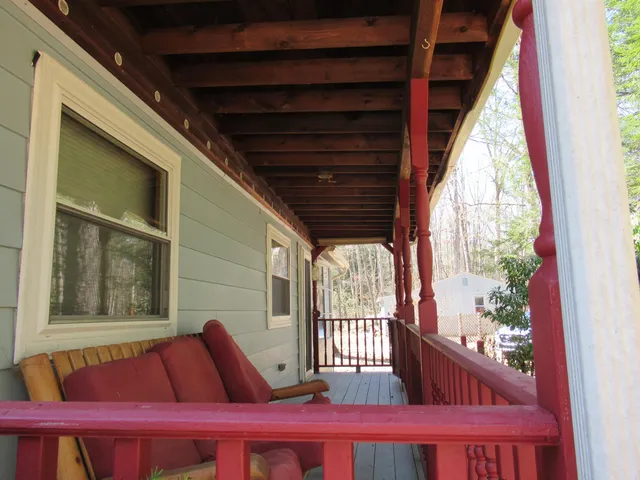a view of a porch with wooden floor and furniture