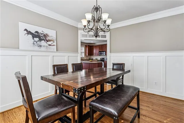 a view of a dining room with furniture a chandelier and wooden floor