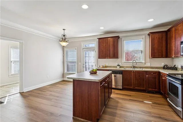 a kitchen with stainless steel appliances granite countertop a sink stove and refrigerator