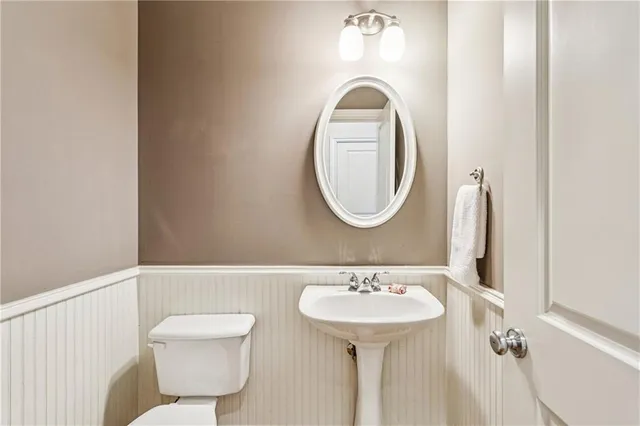a bathroom with a sink mirror and toilet