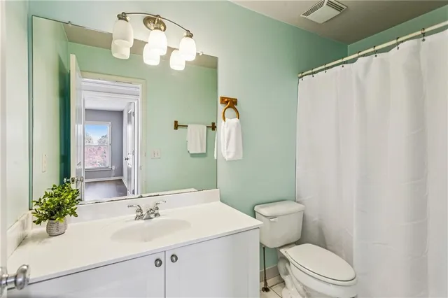 a bathroom with a sink vanity mirror and toilet