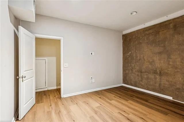 a view of empty room with wooden floor