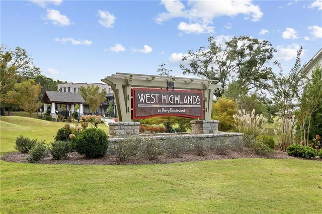 a sign board with a house in the background