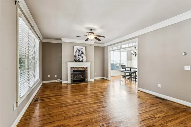 a view of empty room with wooden floor and fireplace