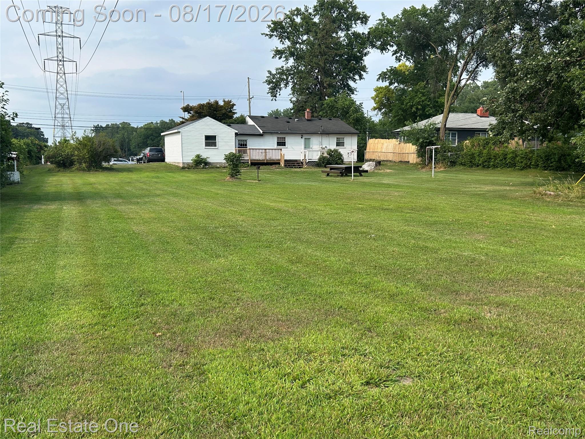 22967 Northline Road Taylor, MI 48180 - Photo 5 of 22 Expansive green lawn with mature trees and a rear deck
