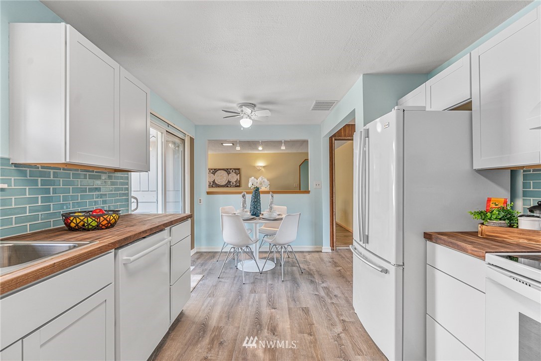 105 232nd Place Southwest Bothell, WA 98021 - Photo 15 of 39 a kitchen with stainless steel appliances a sink a refrigerator and wooden floor