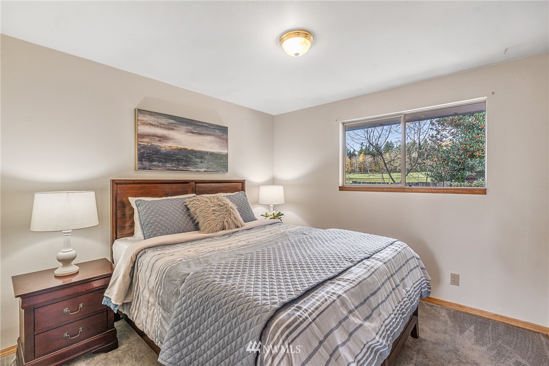 105 232nd Place Southwest Bothell, WA 98021 - Photo 26 of 39 a bedroom with a bed and a lamp on dresser