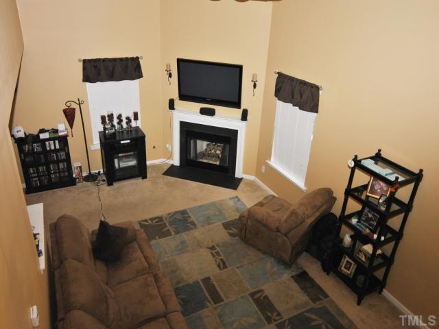 5805 Ricker Road Raleigh, NC 27610 - Photo 2 of 12 a living room with furniture a flat screen tv and a fireplace