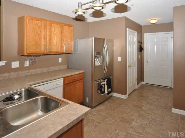 5805 Ricker Road Raleigh, NC 27610 - Photo 3 of 12 a kitchen with a sink and a refrigerator