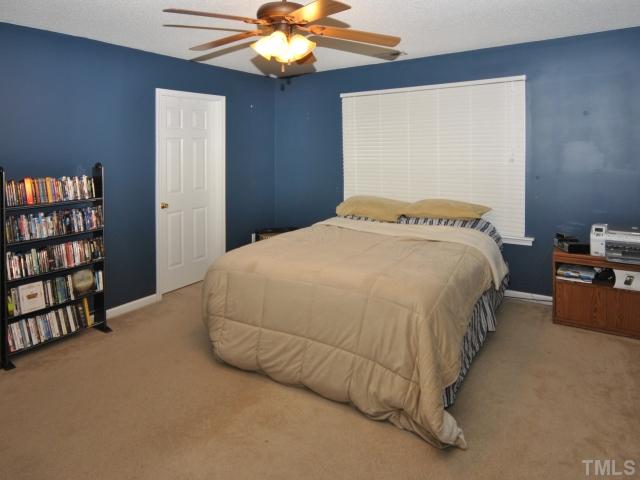 5805 Ricker Road Raleigh, NC 27610 - Photo 5 of 12 a bedroom with a bed and a book shelf