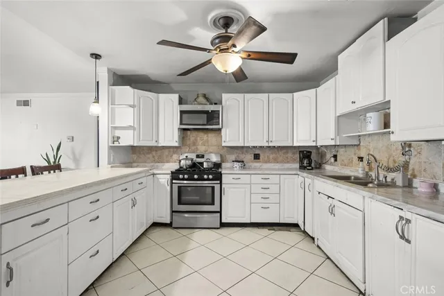 a kitchen with cabinets appliances a sink and a window