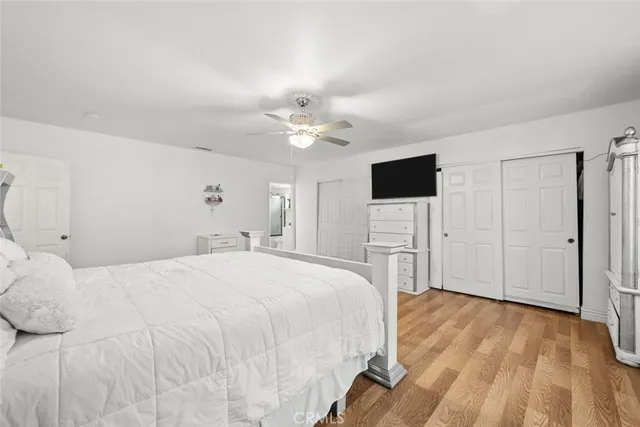 a spacious bedroom with a bed and a flat screen tv