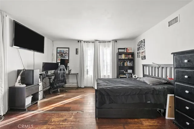 a bedroom with a bed flat screen tv and a large window