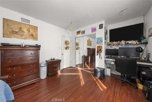 a livingroom with workspace and a flat screen tv