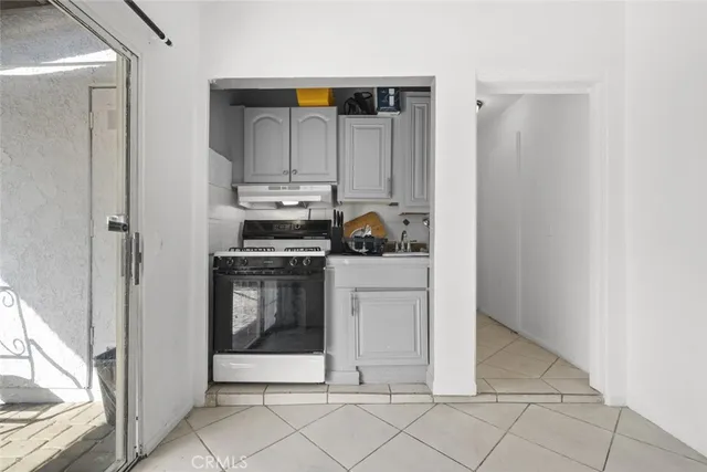 a kitchen with white cabinets and appliances