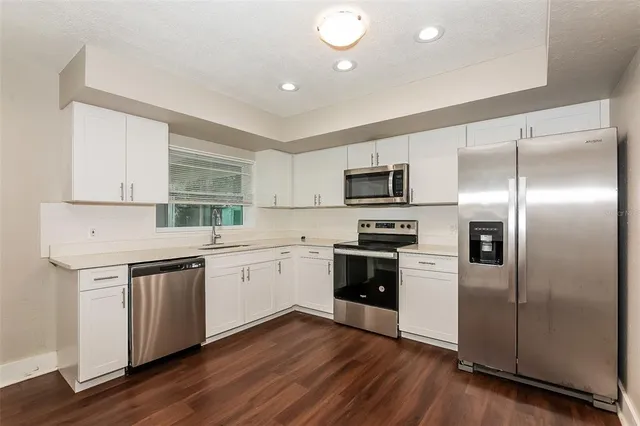 a kitchen with a sink stainless steel appliances and window