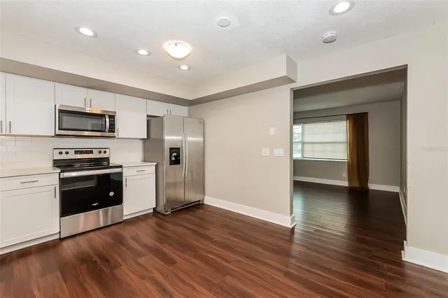 a kitchen with a refrigerator and a stove top oven