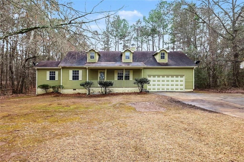 a view of a white house with large windows and a small yard