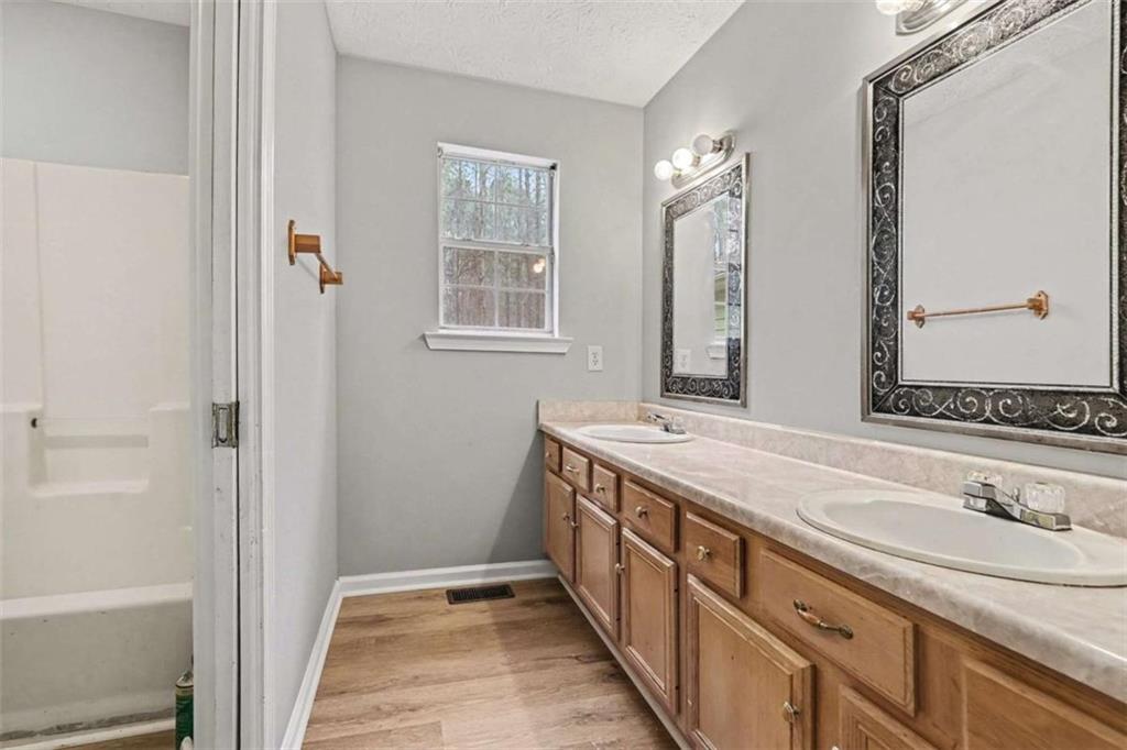 253 Ruth Drive Newnan, GA 30265 - Photo 15 of 25 a bathroom with a granite countertop sink and a mirror