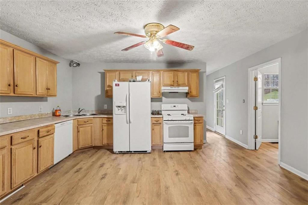 253 Ruth Drive Newnan, GA 30265 - Photo 7 of 25 a kitchen with refrigerator cabinets and wooden floor