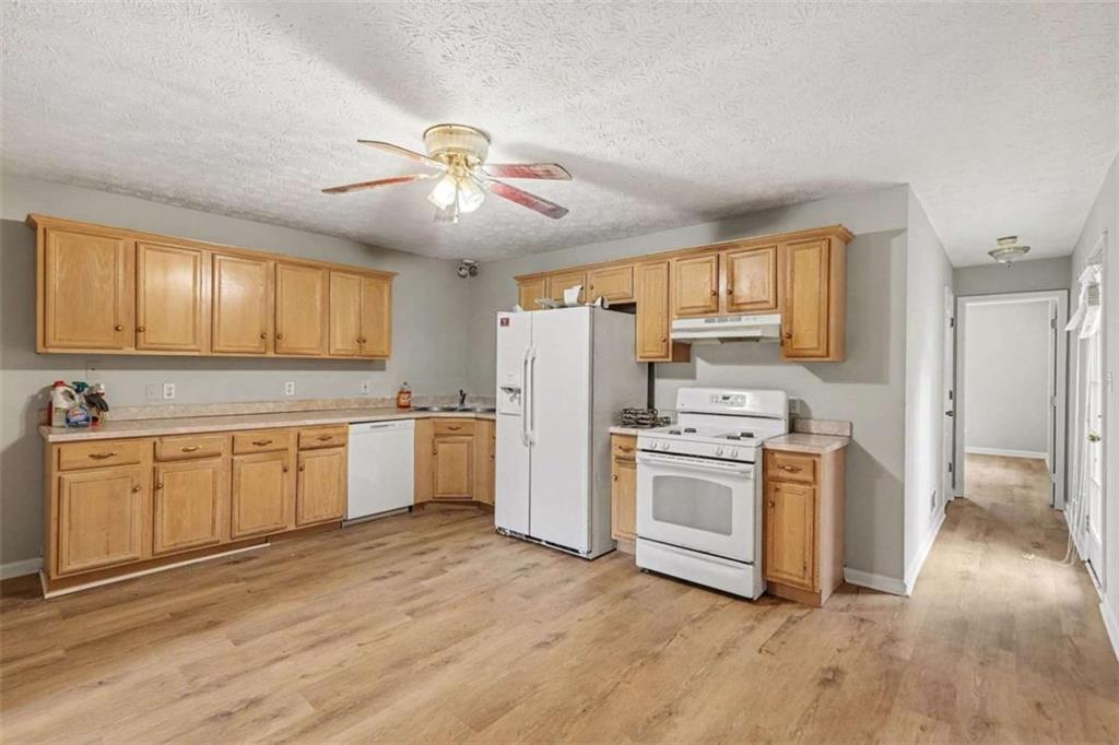 253 Ruth Drive Newnan, GA 30265 - Photo 8 of 25 a kitchen with white cabinets and white appliances