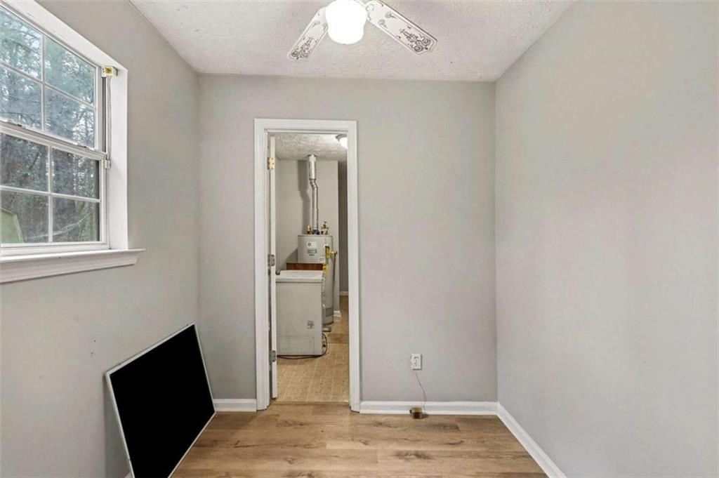 253 Ruth Drive Newnan, GA 30265 - Photo 10 of 25 an empty room with wooden floor cabinet and a mirror