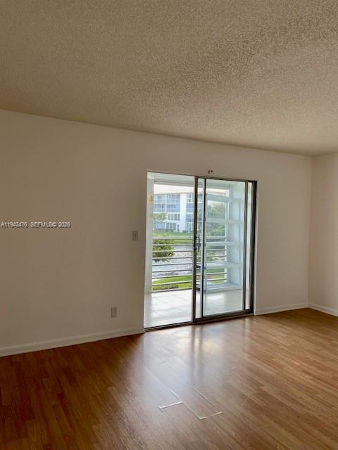 1902 Bermuda Circle, Unit E2 Coconut Creek, FL 33066 - Photo 8 of 30 an empty room with wooden floor and windows