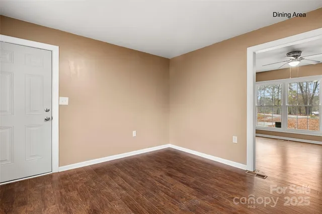 a view of a big room with wooden floor and windows