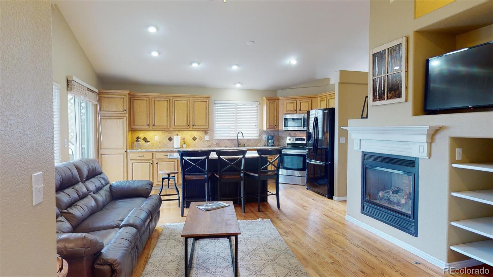 599 Timbervale Trail Highlands Ranch, CO 80129 - Photo 11 of 32 a living room with fireplace furniture and a flat screen tv