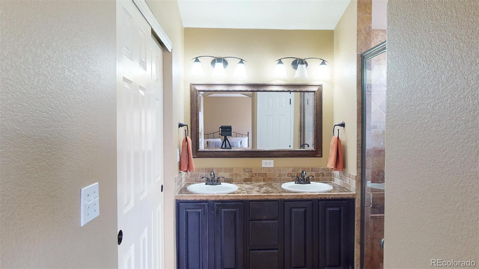 599 Timbervale Trail Highlands Ranch, CO 80129 - Photo 17 of 32 a bathroom with a sink and mirror
