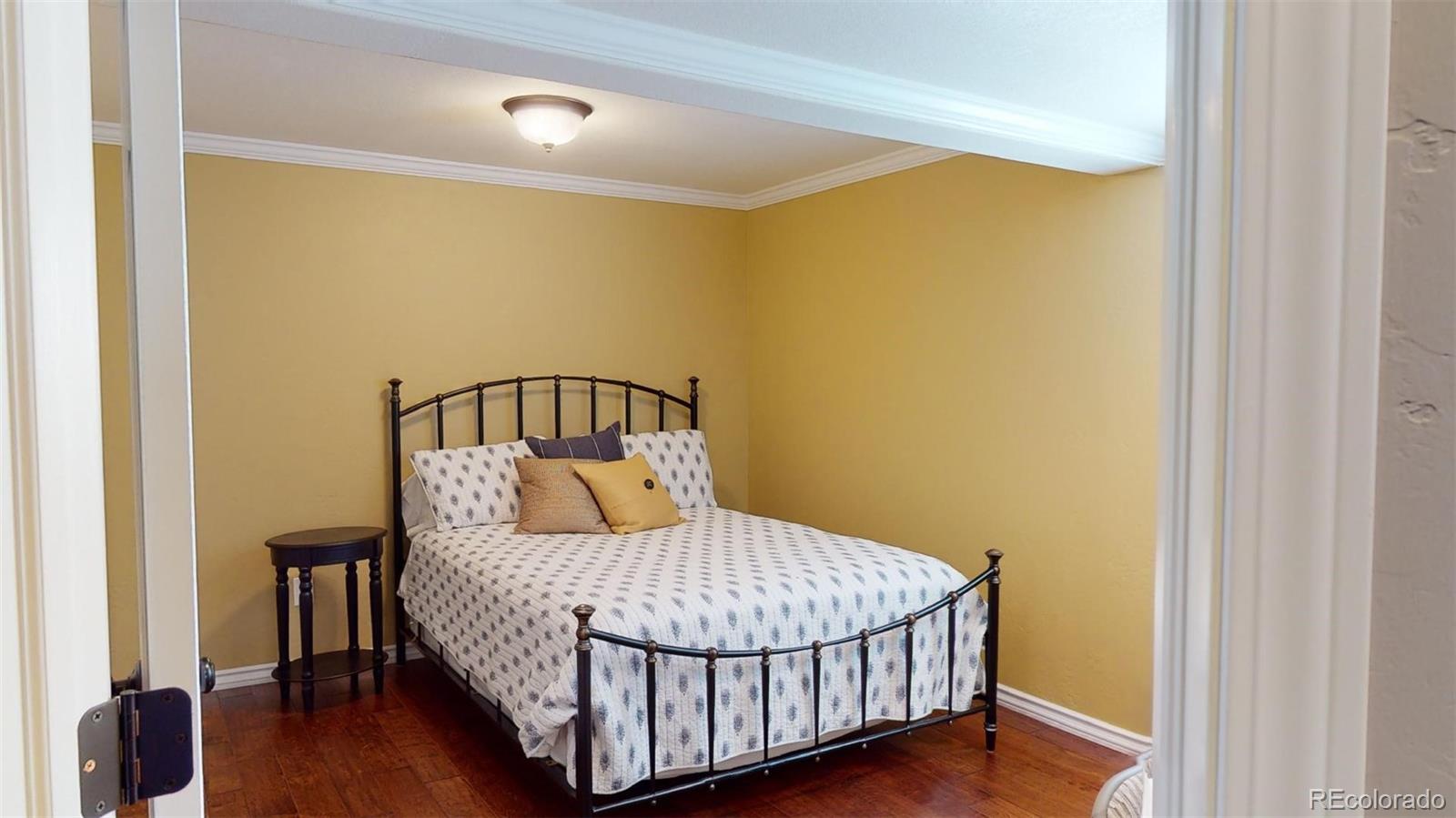 599 Timbervale Trail Highlands Ranch, CO 80129 - Photo 26 of 32 a bedroom with a bed and wooden floor