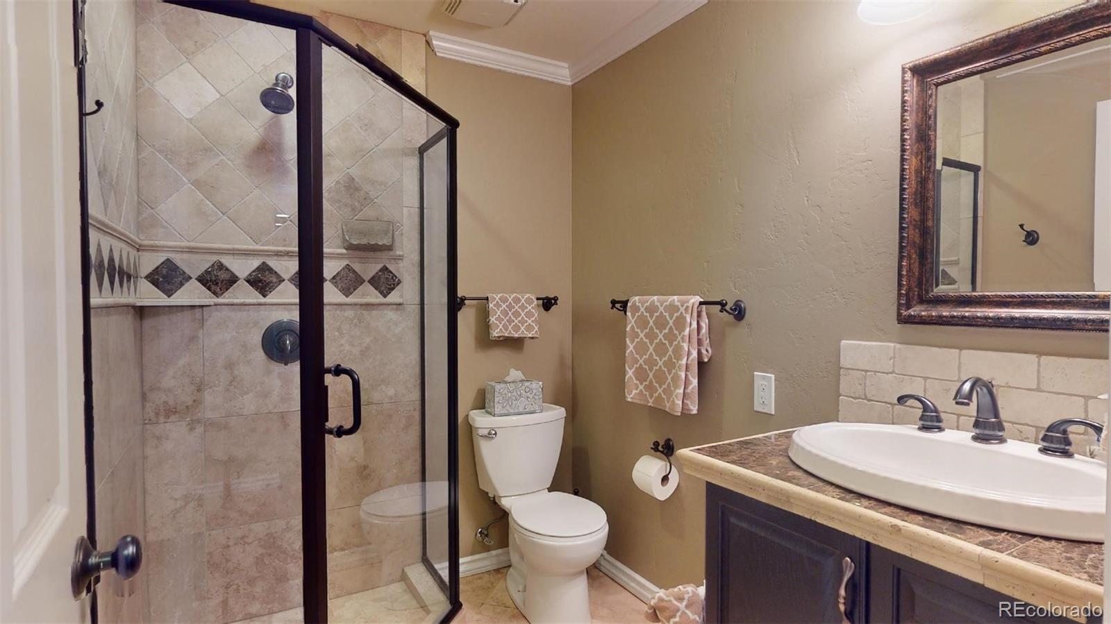 599 Timbervale Trail Highlands Ranch, CO 80129 - Photo 27 of 32 a bathroom with a sink vanity mirror and toilet