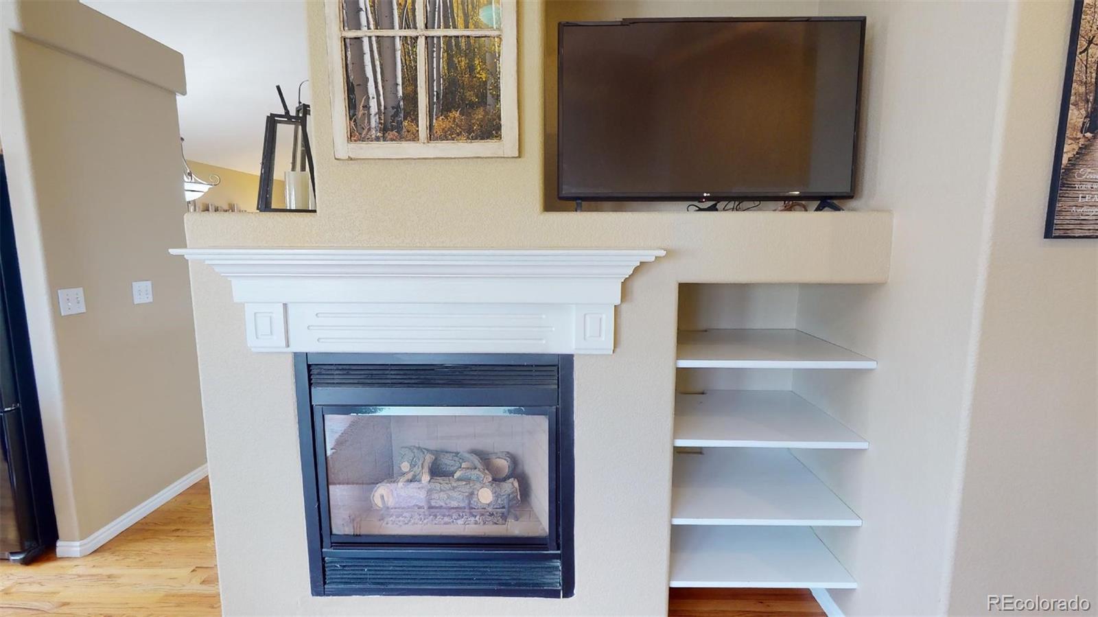 599 Timbervale Trail Highlands Ranch, CO 80129 - Photo 10 of 32 a living room with a fireplace and a flat screen tv