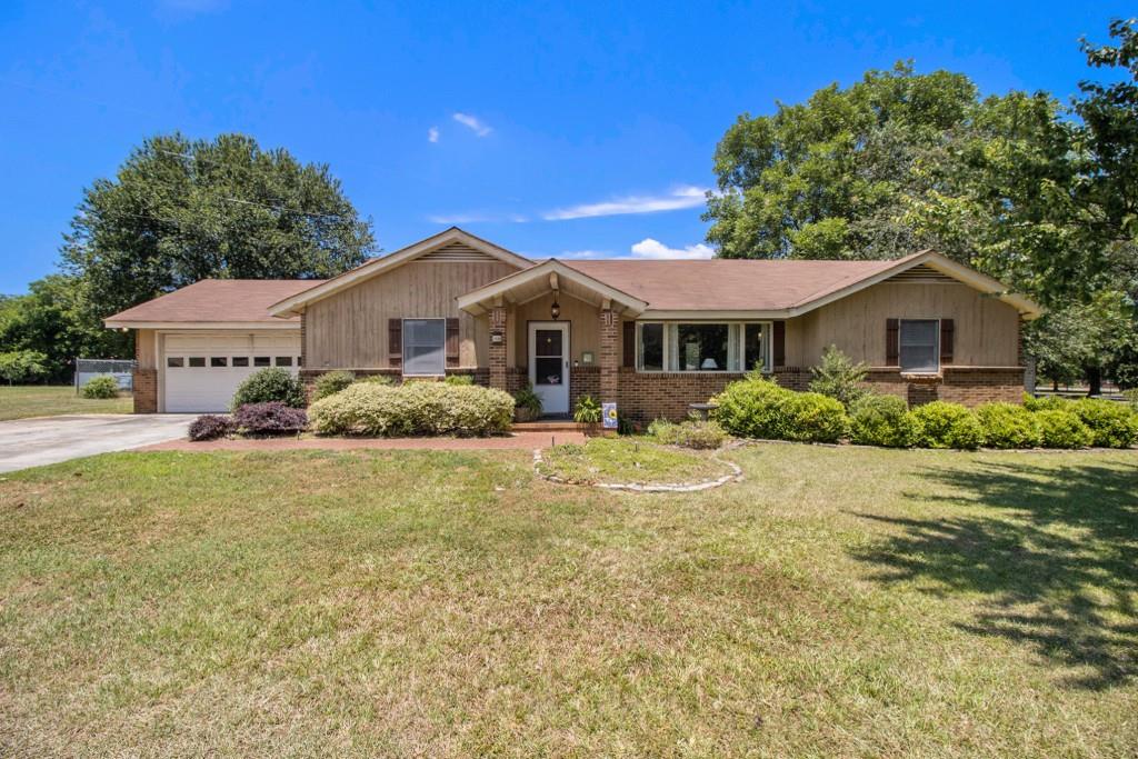 1080 Carmichael Road Madison, GA 30650 - Photo 1 of 1 a front view of a house with a garden