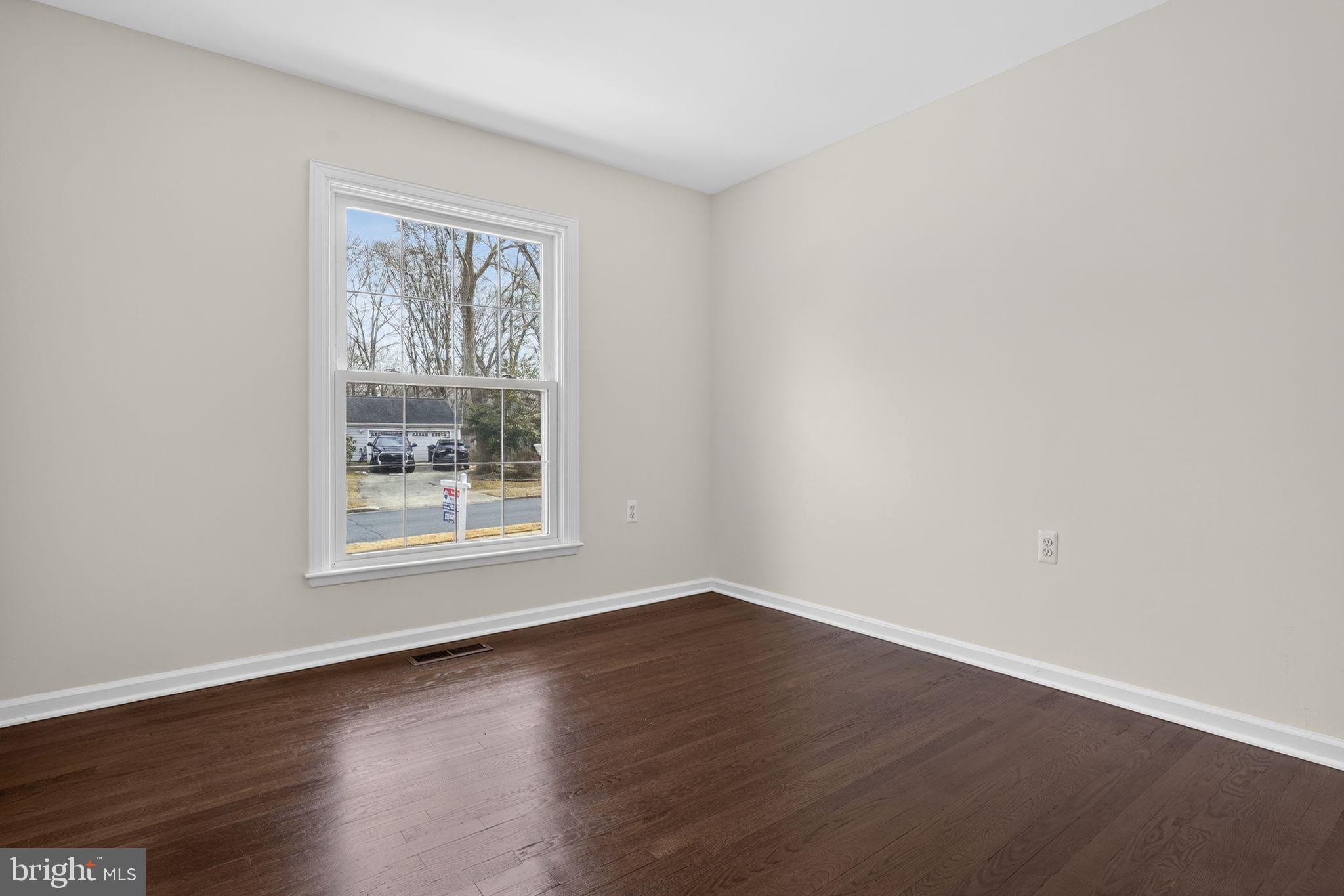 1629 Eton Way Crofton, MD 21114 - Photo 25 of 46 a view of an empty room with wooden floor and a window