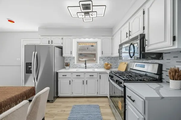 a kitchen with stainless steel appliances granite countertop a stove a sink dishwasher and a refrigerator