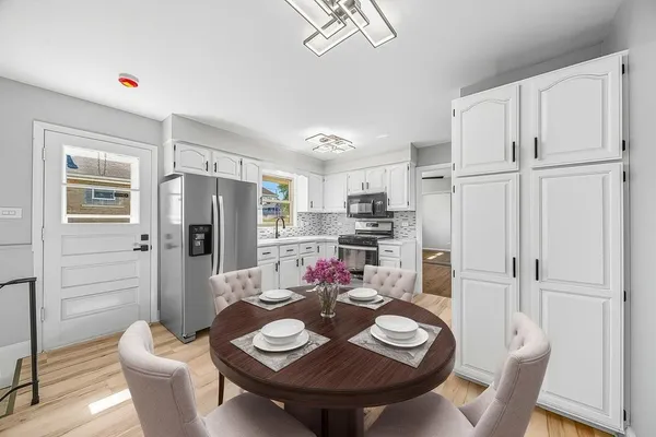 a view of a dining room with furniture a kitchen and chandelier
