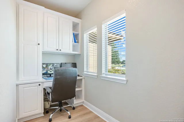 a view of an empty room with a window and a ceiling fan