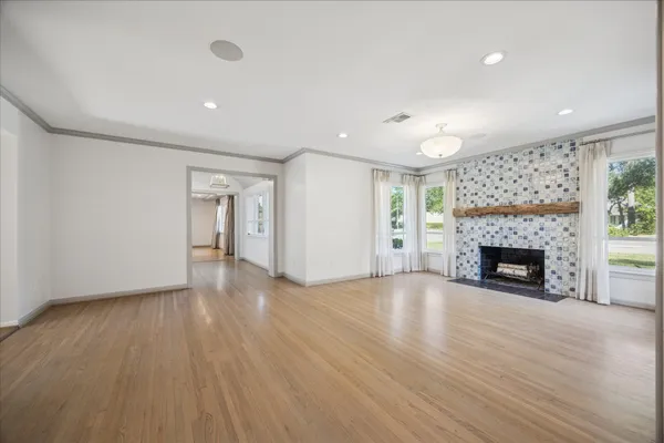 an empty room with windows and fireplace