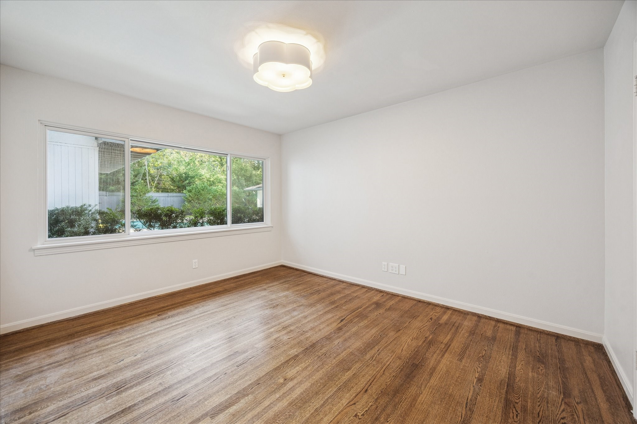 547 3 Corners Drive Hunters Creek Village, TX 77024 - Photo 8 of 17 a view of an empty room with wooden floor and a window